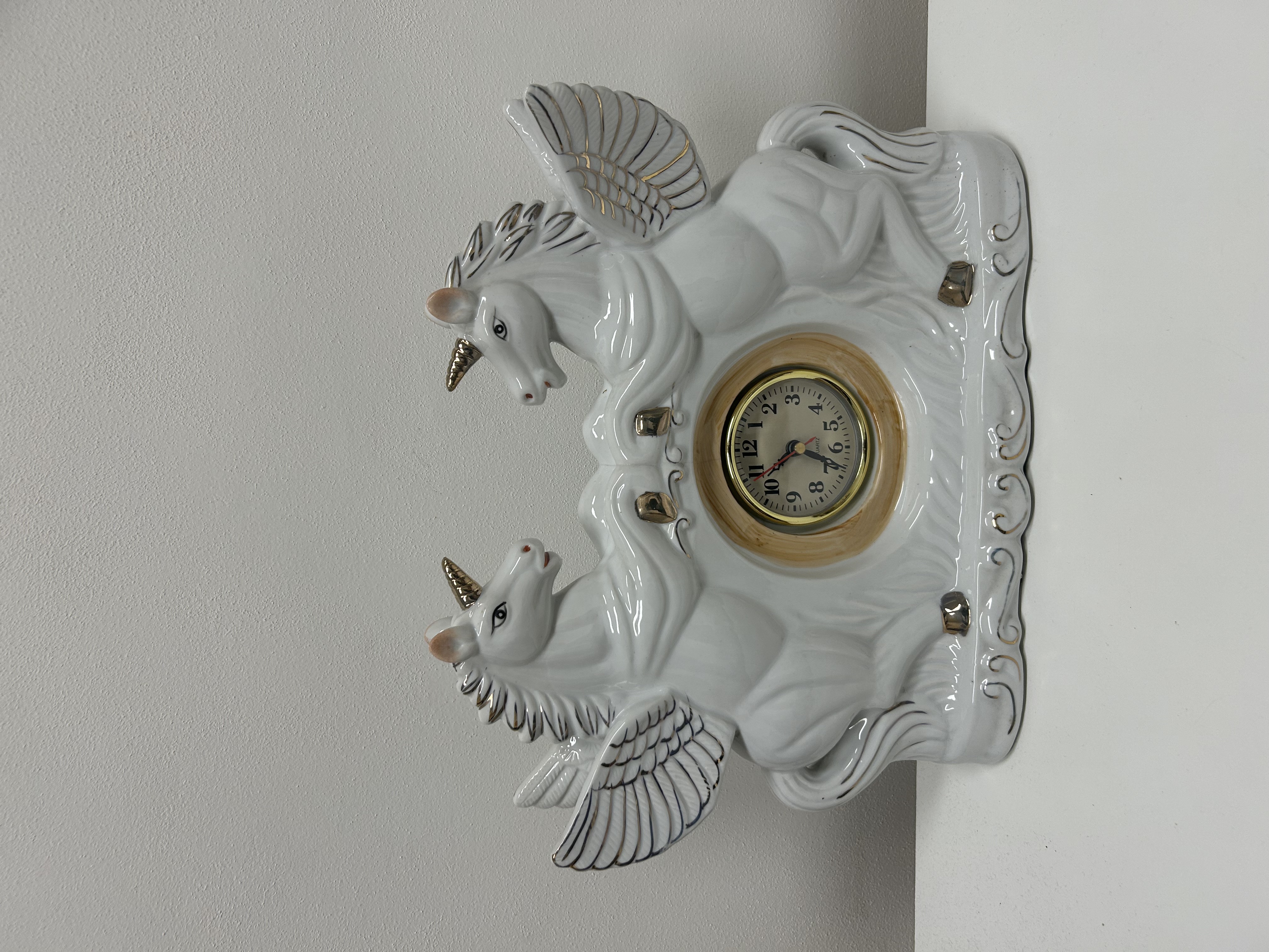 Porcelánové hodiny s okřídlenými jednorožci